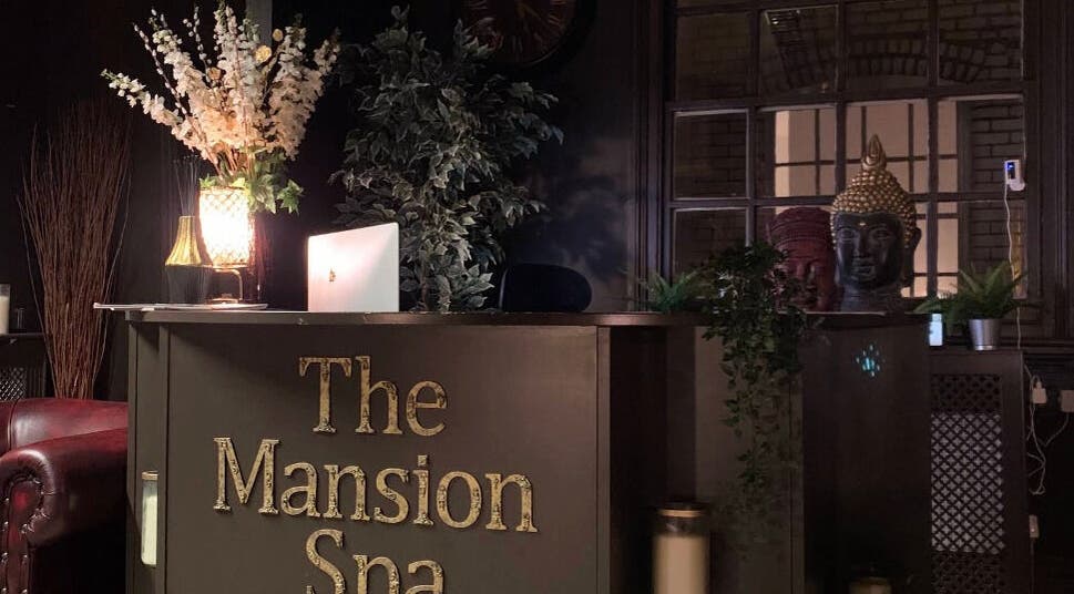 Reception area at The Mansion Spa in Birmingham, England, GB, featuring elegant decor and warm lighting.