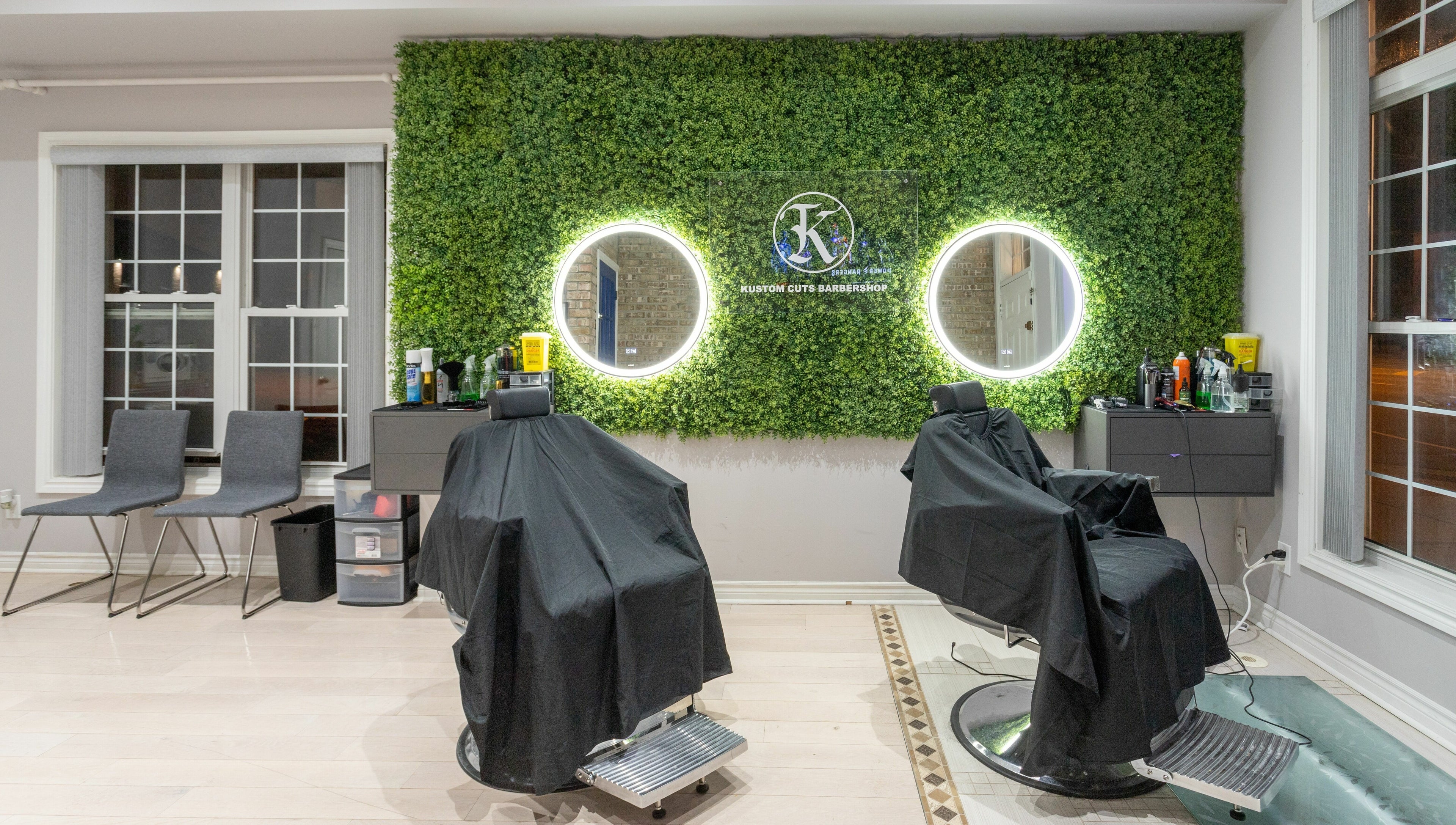 KustomCuts barbershop in Toronto, Ontario, CA features greenery wall and modern styling chairs.