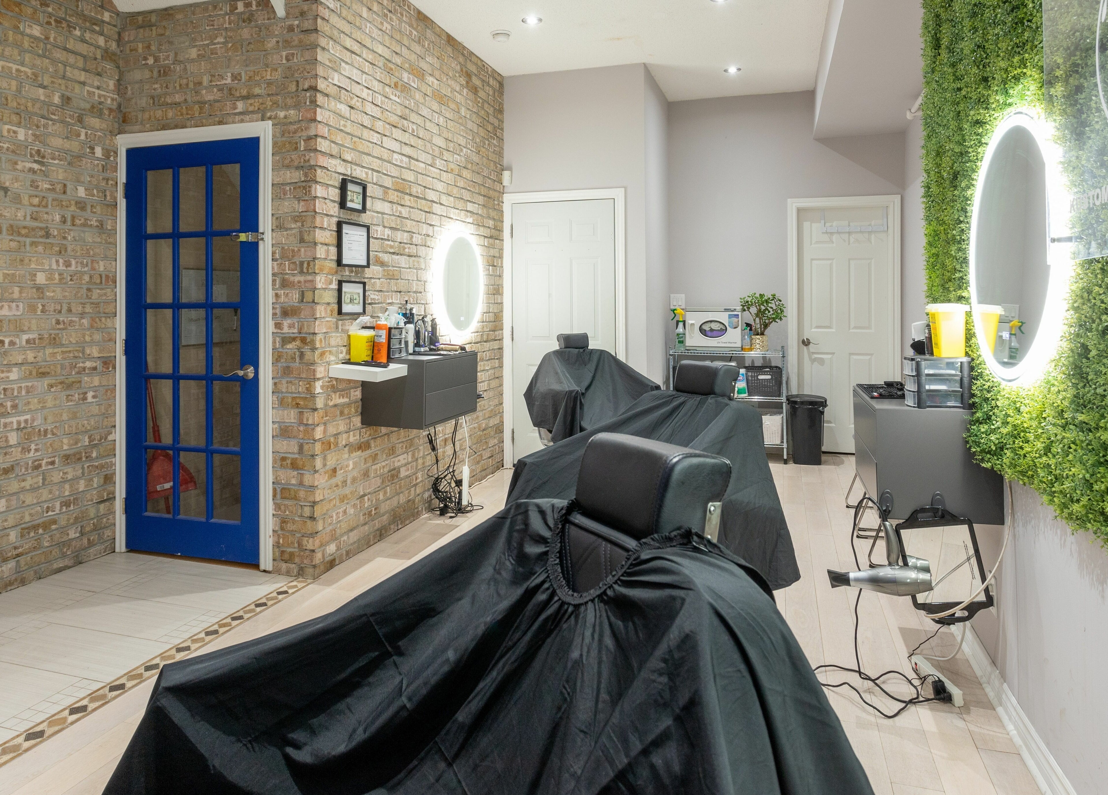 Modern interior of KustomCuts in Toronto, Ontario, CA with stylish barber chairs and vibrant decor.