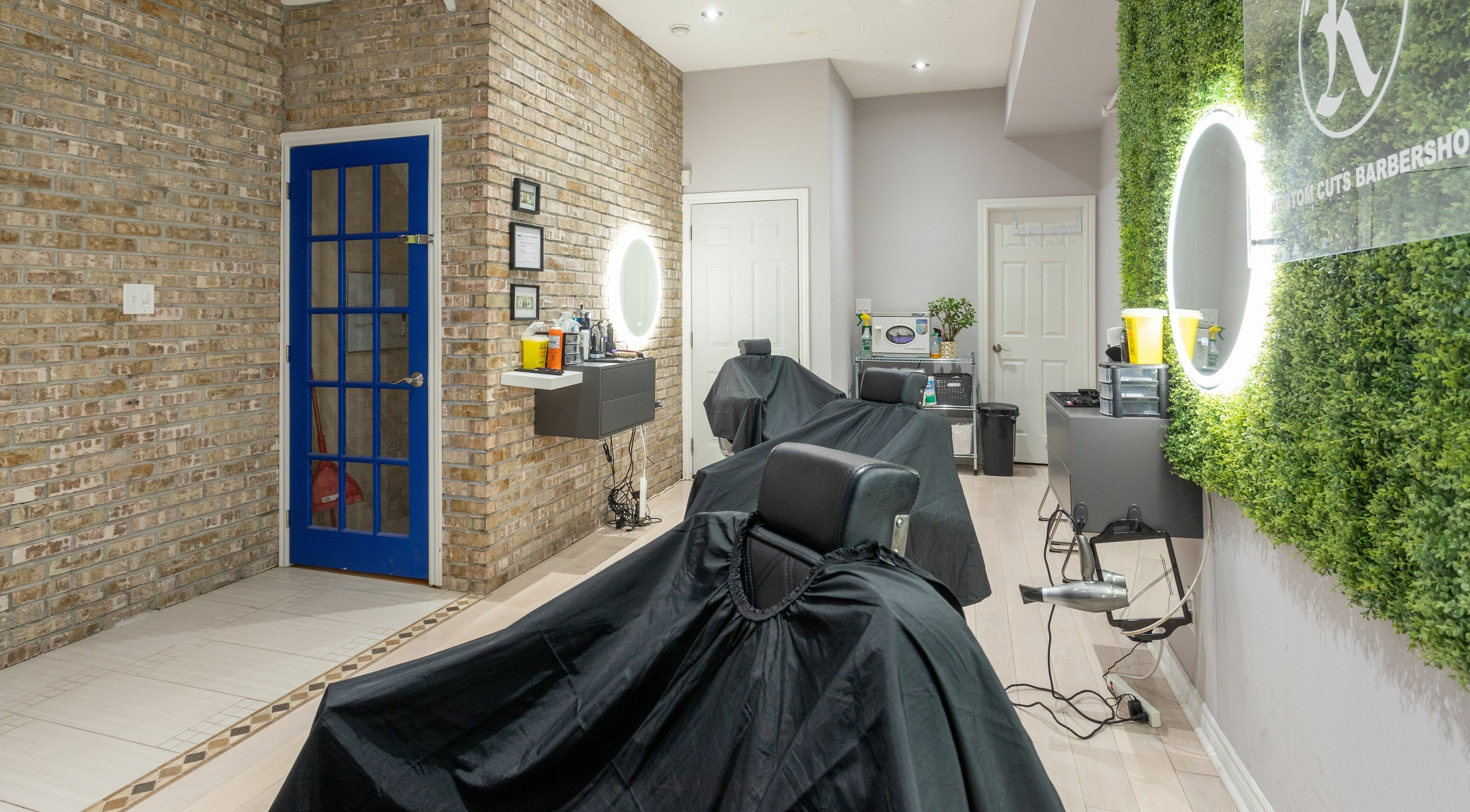 Modern interior of KustomCuts in Toronto, Ontario, CA with stylish barber chairs and vibrant decor.