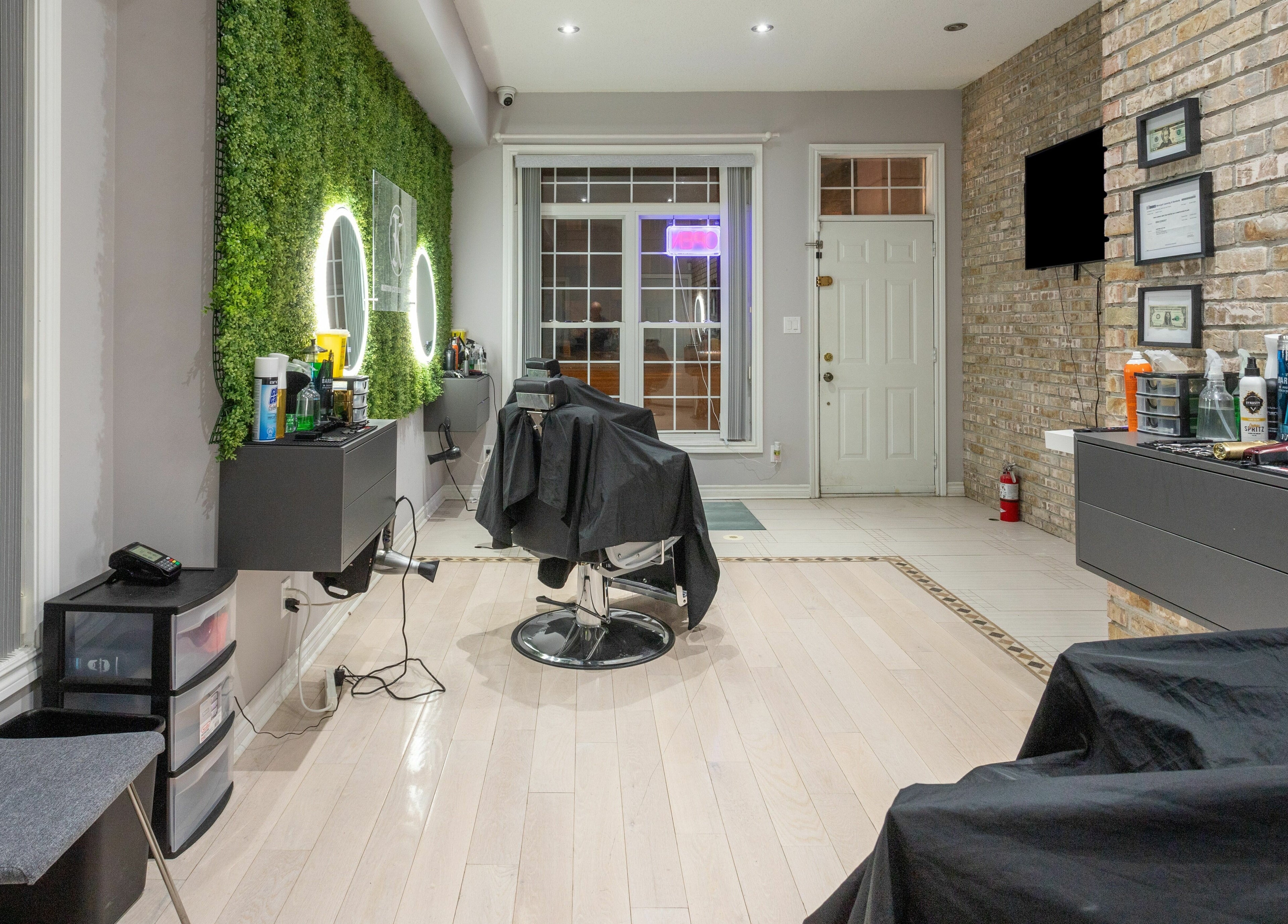 Modern salon interior at KustomCuts, Toronto, Ontario, CA showcasing stylish barber chairs and vibrant green wall.