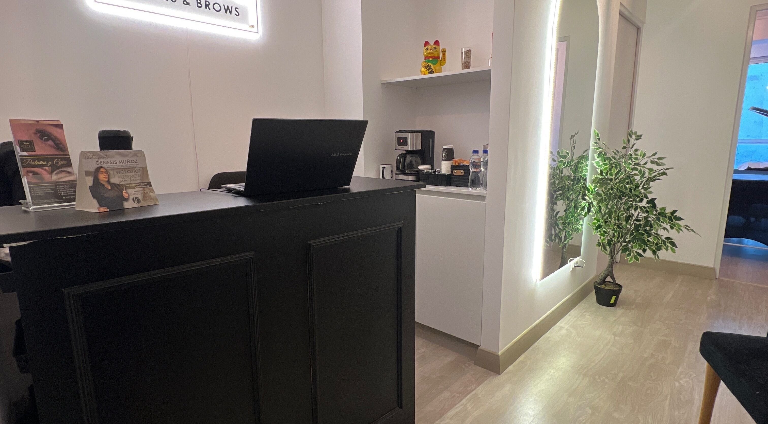 Recepción moderna en Génesis - Lashes & Brows, Barranco, Provincia De Lima, PE, con mesa negra y decoración minimalista.