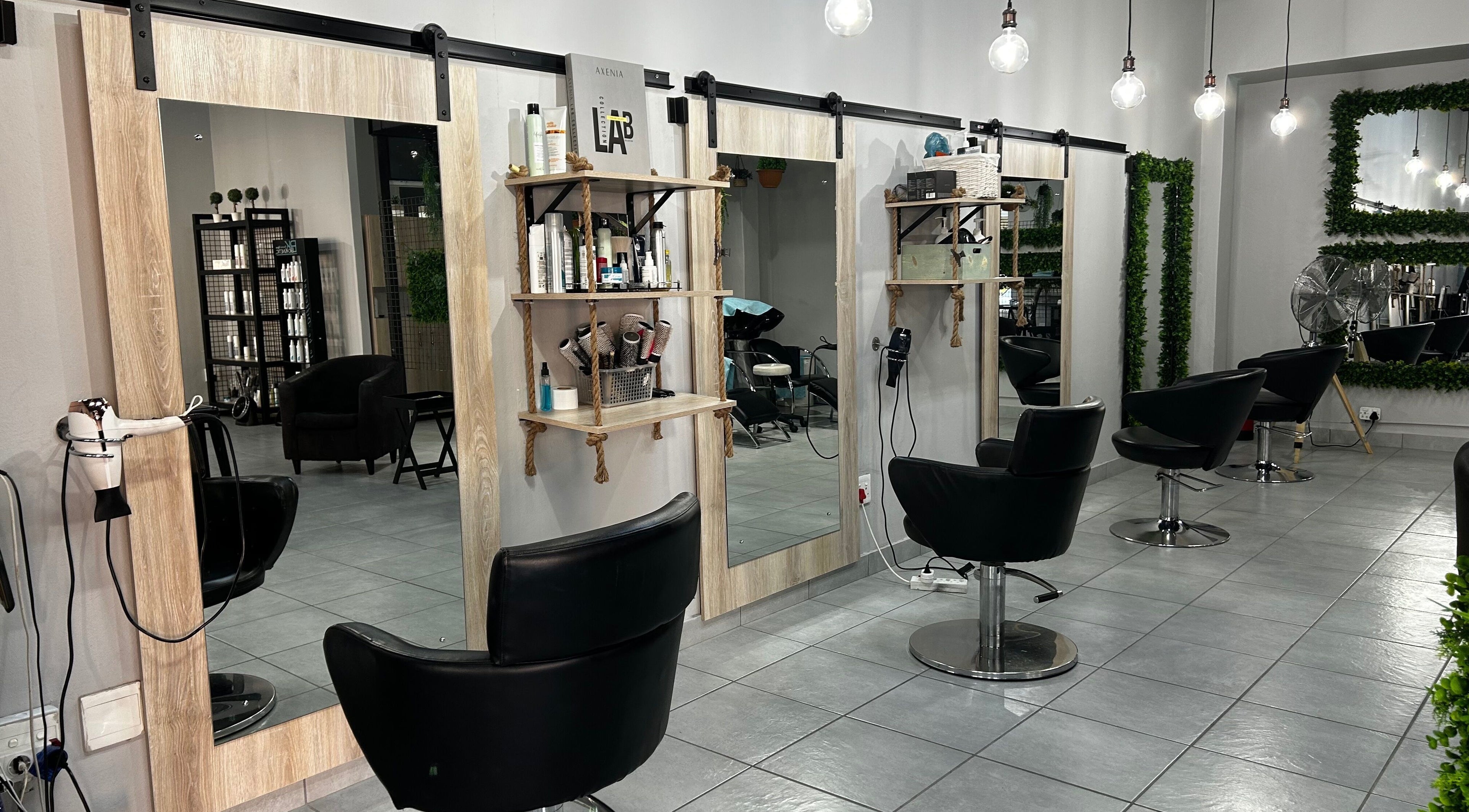 Modern salon chairs and mirrors at Envy Hair Design, Boksburg, Gauteng, ZA, showcasing sleek design and elegance.
