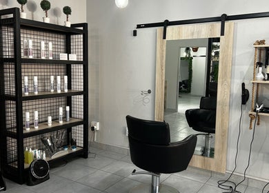 Envy Hair Design salon corner with styling products in Boksburg, Gauteng, ZA, featuring a mirror and chair.