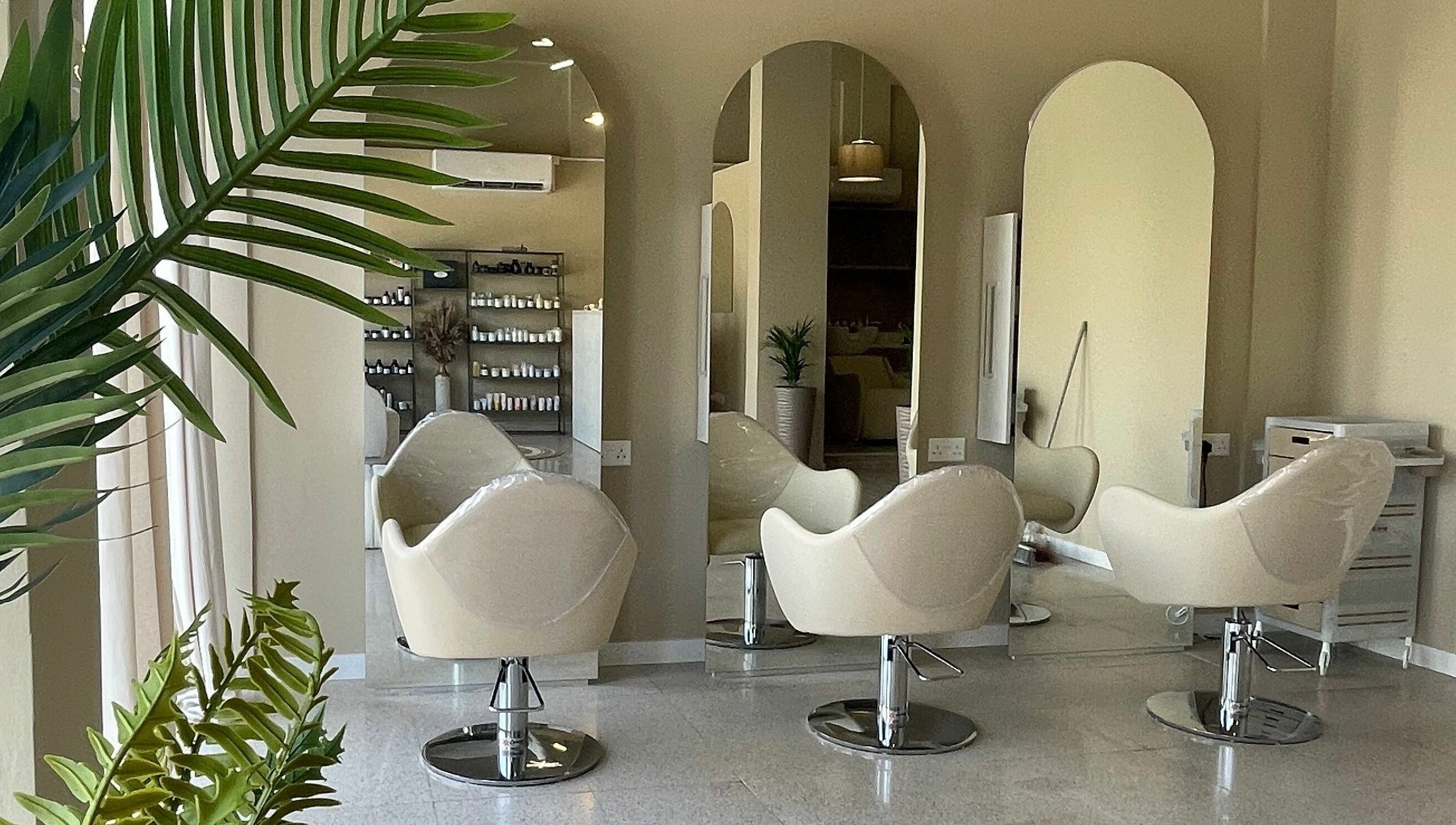 Καθίσματα στο HAIR HUB, κομμωτήριο στη Λευκωσία, Λευκωσία, CY, με καθρέπτες και φυτά.