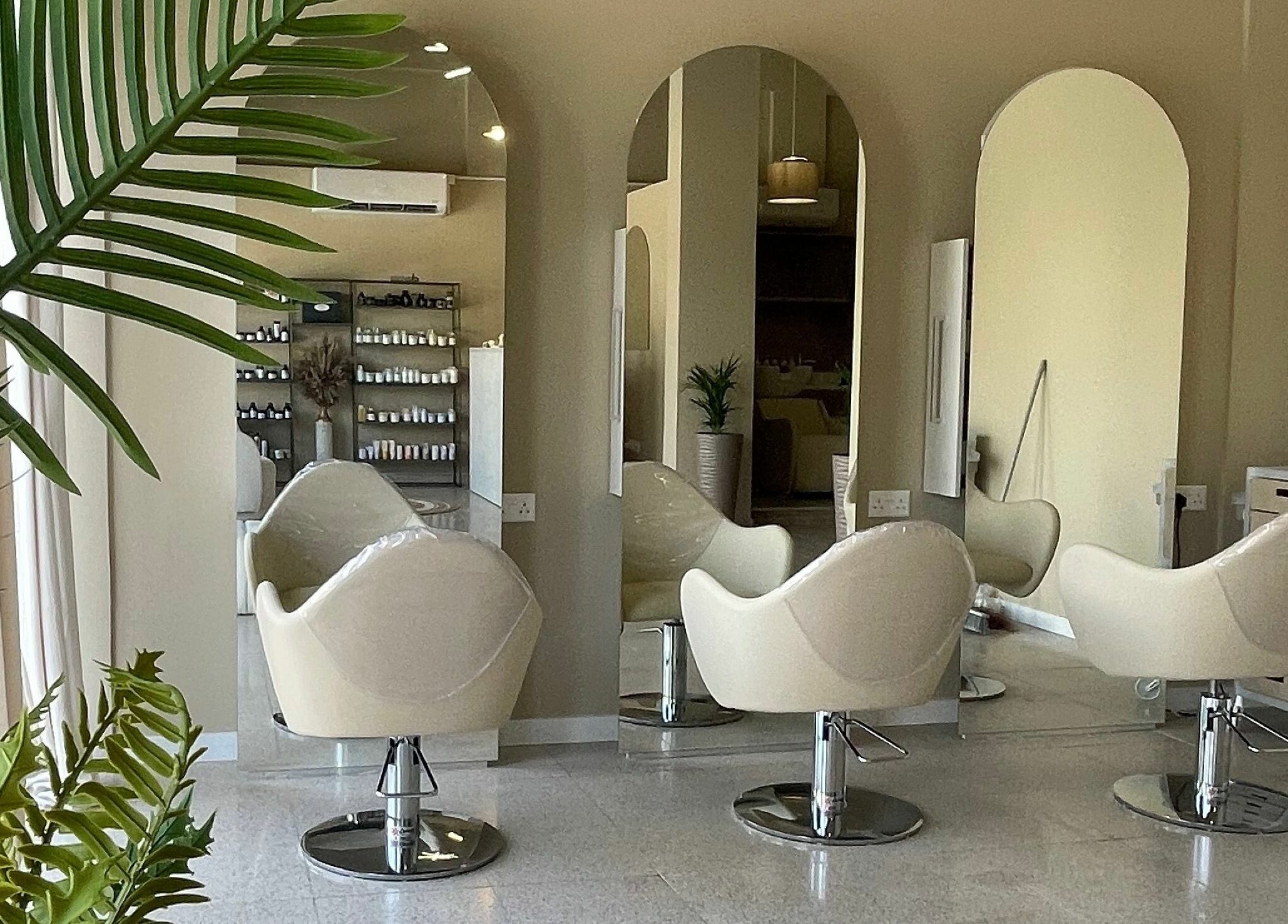 Καθίσματα στο HAIR HUB, κομμωτήριο στη Λευκωσία, Λευκωσία, CY, με καθρέπτες και φυτά.