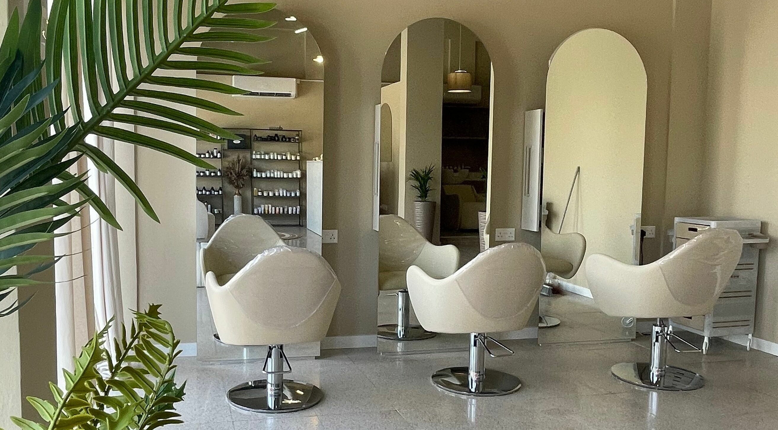 Καθίσματα στο HAIR HUB, κομμωτήριο στη Λευκωσία, Λευκωσία, CY, με καθρέπτες και φυτά.