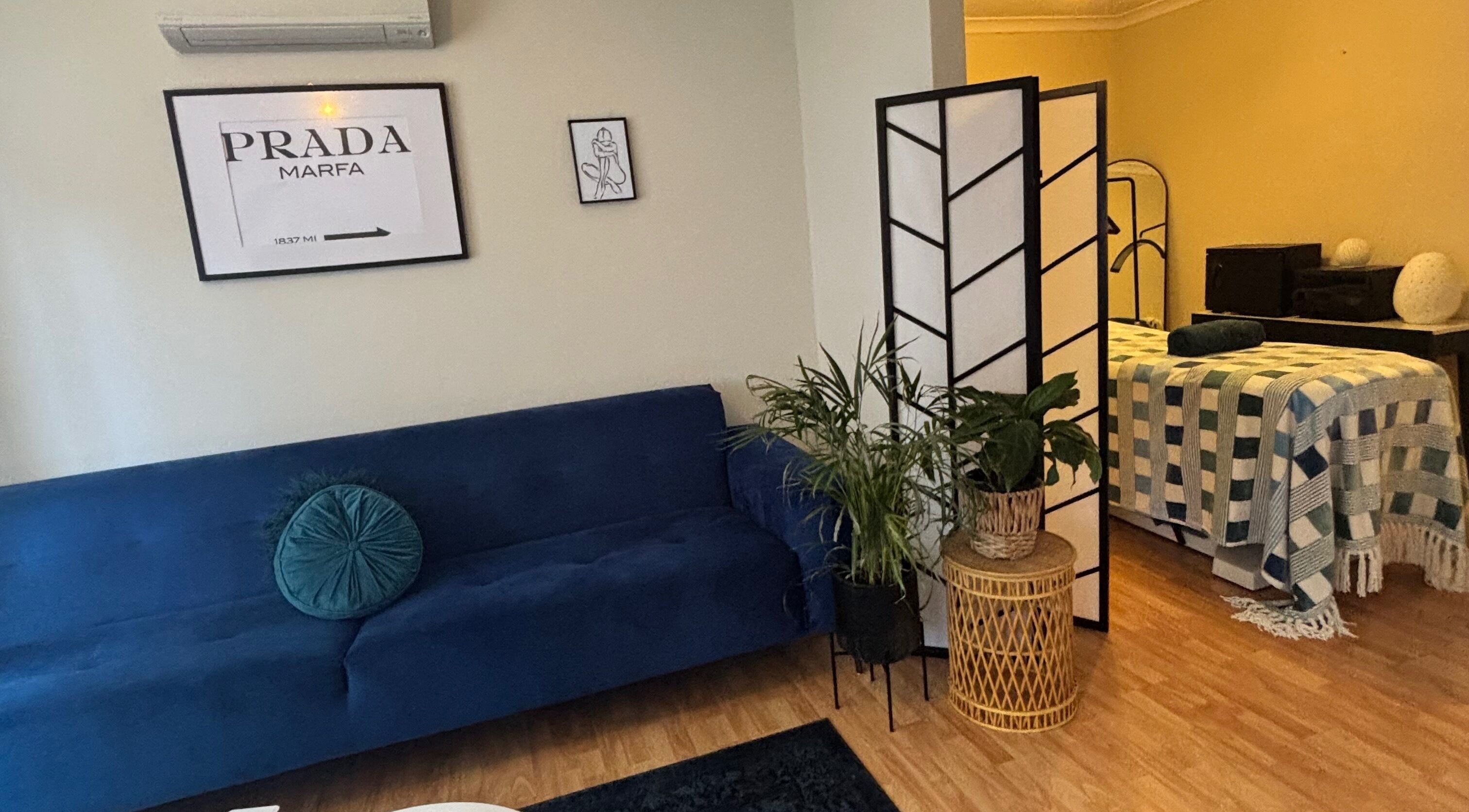 Relaxing massage area at Glow With Elegant Faces, Scarborough, Western Australia, AU with blue sofa and decor.