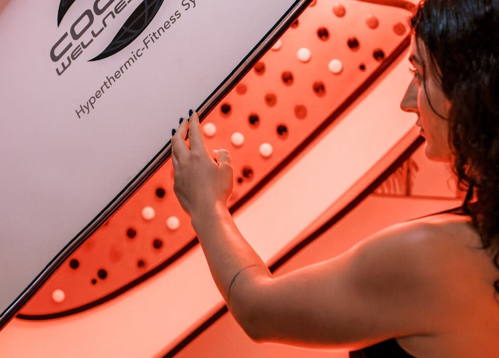Woman adjusting an infrared wellness pod at Bodyspace Recovery Studio, Jandakot, Western Australia, AU.