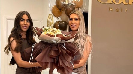 Two stylists at JessicaLibbyHair Hinckley, England, GB, holding a bouquet and smiling amid decor.