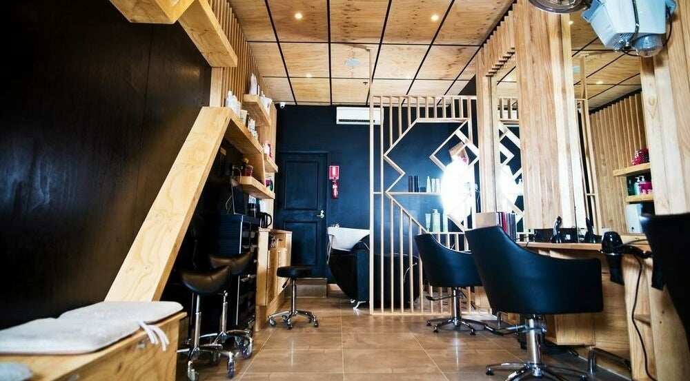 Stylish interior of Who Salon at Lonsdale St in Melbourne, Victoria, AU with modern wooden design and black chairs.