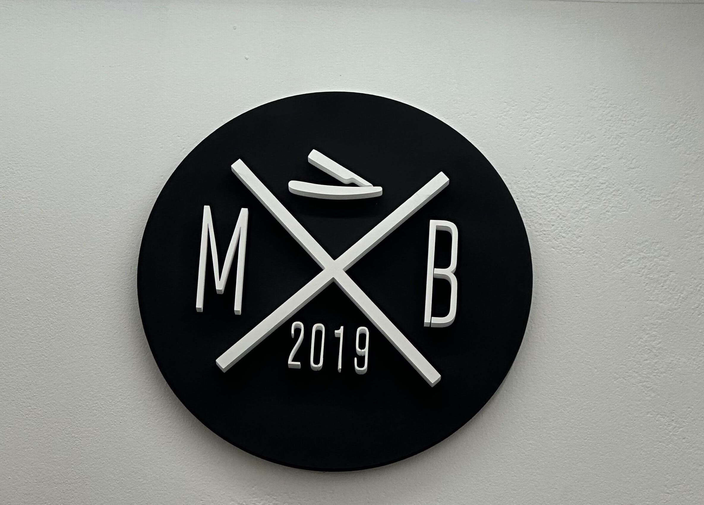 Logotipo de MB Barber en San Nicolás de los Arroyos, un diseño moderno en fondo negro.