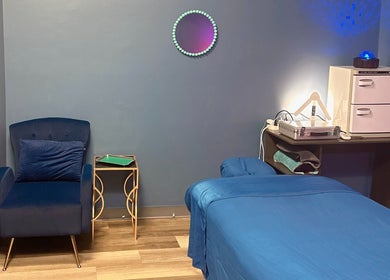 Serene massage room at Master Massage and Spa in Knoxville, Tennessee, US featuring a blue chair and bed.
