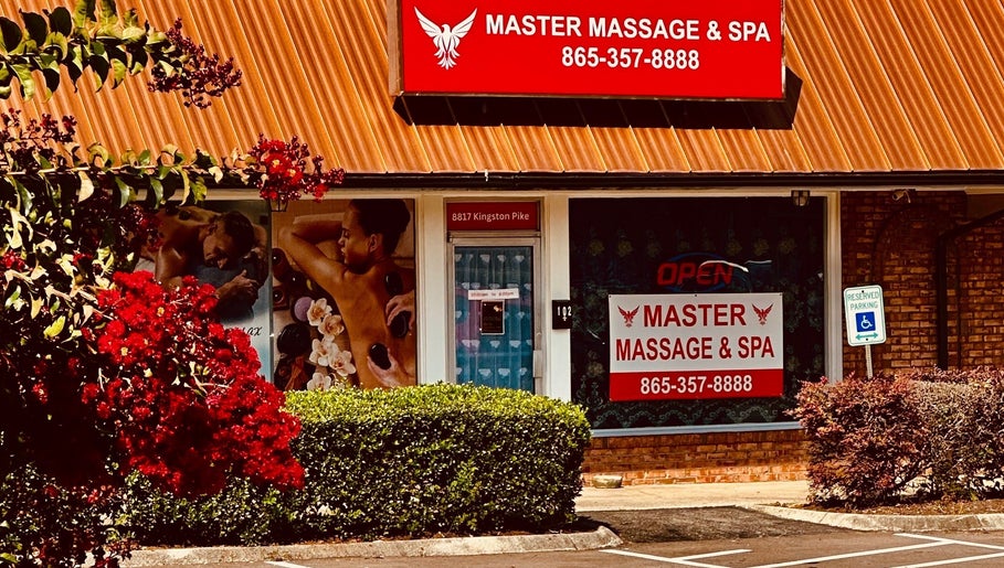 Entrance of Master Massage and Spa in Knoxville, Tennessee, US, featuring vibrant signage and lush greenery.