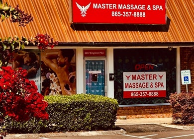 Entrance of Master Massage and Spa in Knoxville, Tennessee, US, featuring vibrant signage and lush greenery.