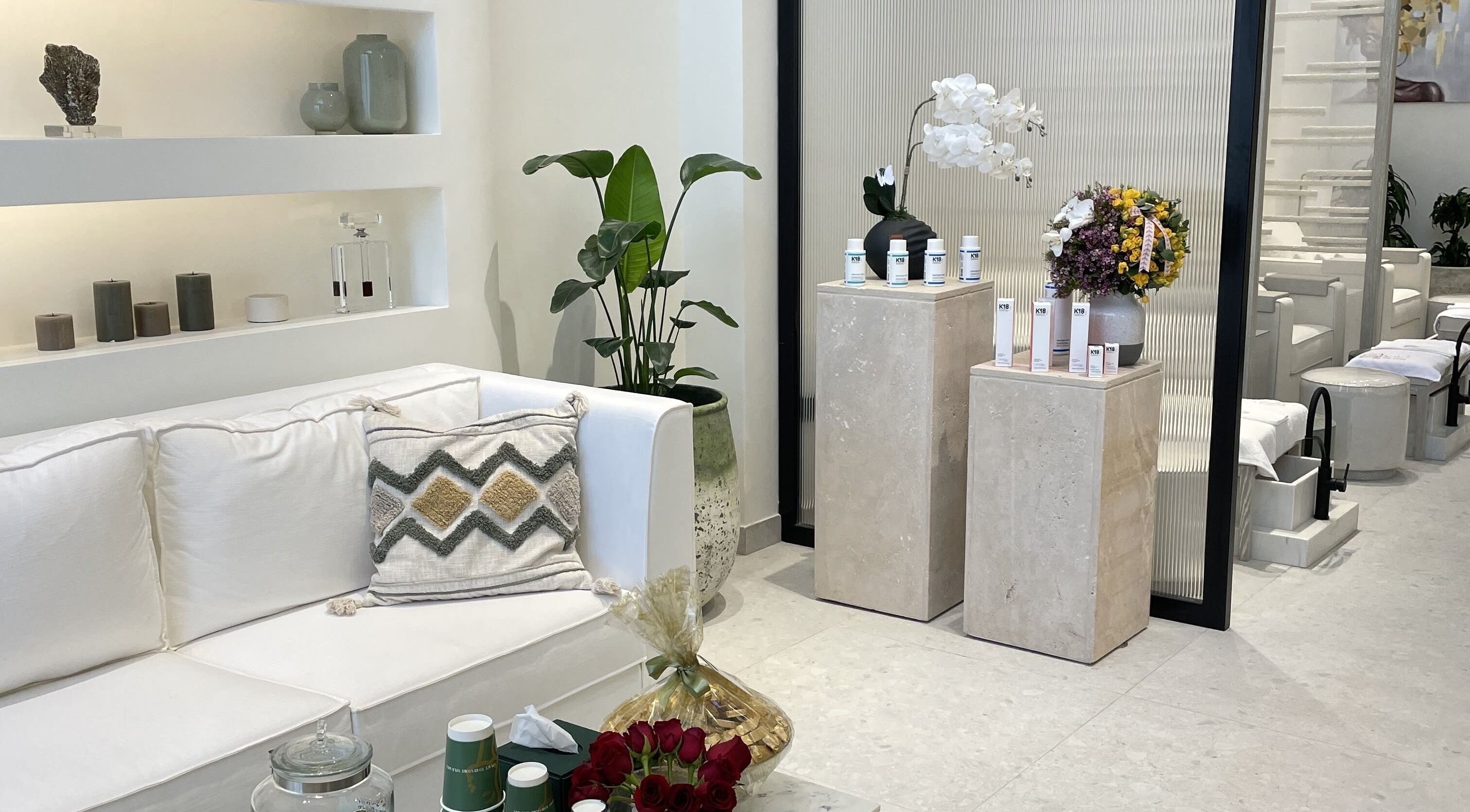 Elegant lounge area of Philautia Salon, Riyadh, with modern decor and floral accents for a relaxing atmosphere.