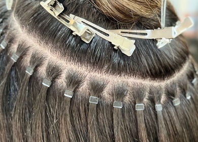 Hair extensions application at Aura Extensions, Twickenham, England, GB, showcasing expert craftsmanship.