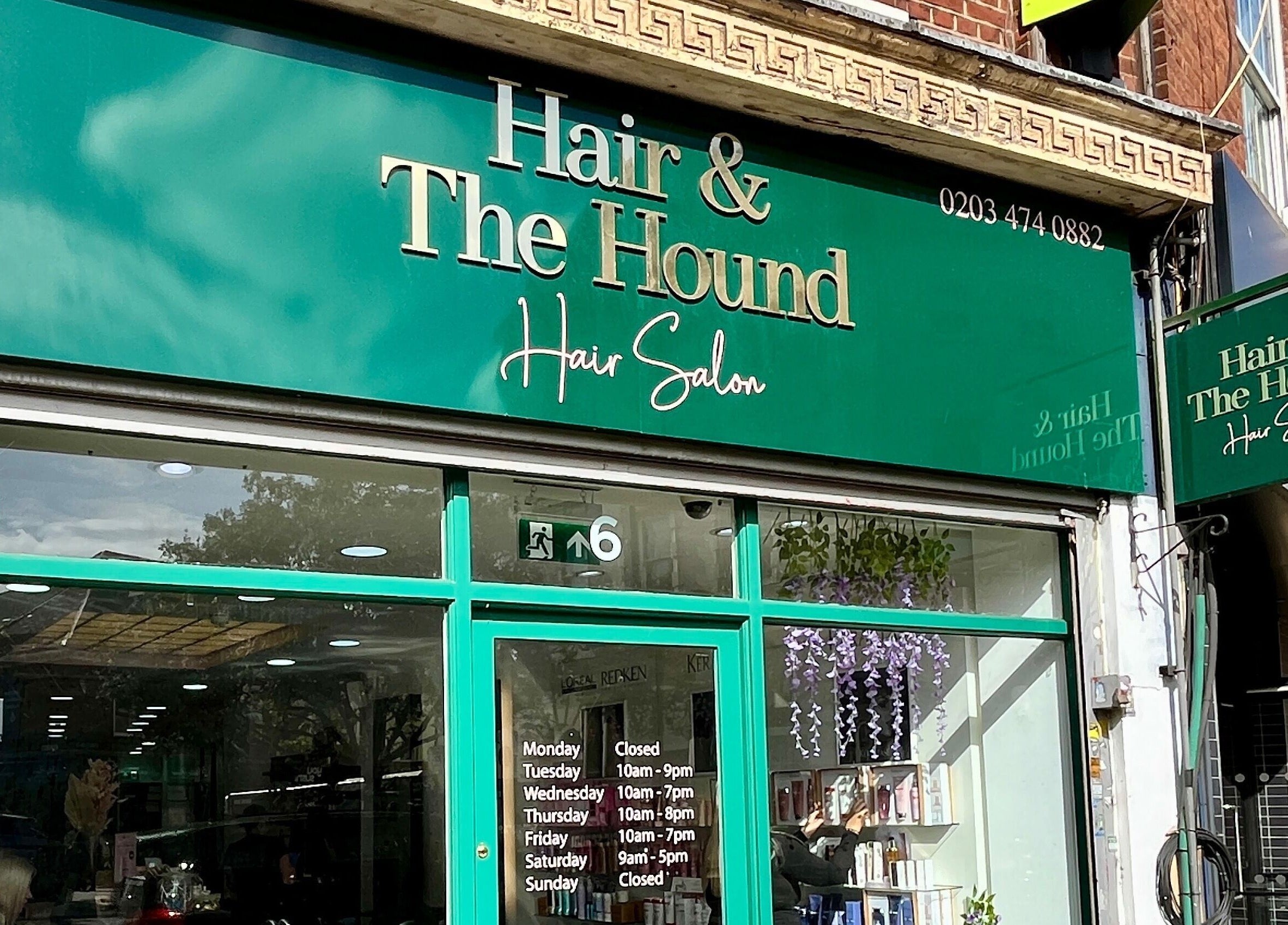 Front view of Aura Extensions, a beauty salon at Twickenham, England, GB. Green signage with opening hours visible.