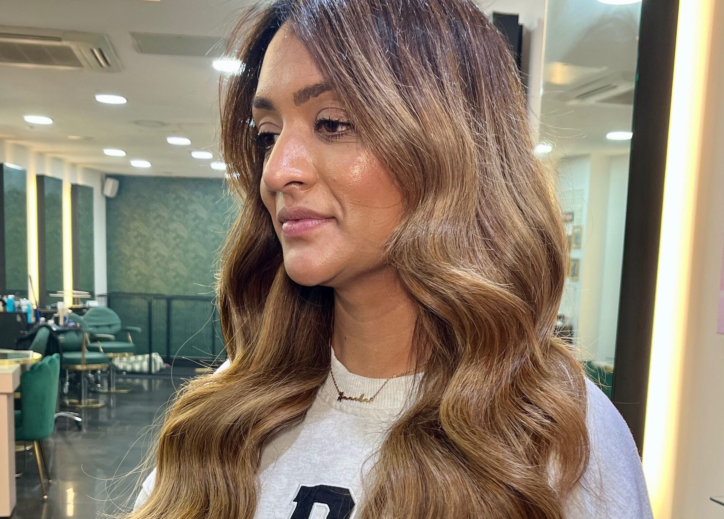 Warm-toned hair styled with waves at Aura Extensions, Twickenham, England, GB salon interior.