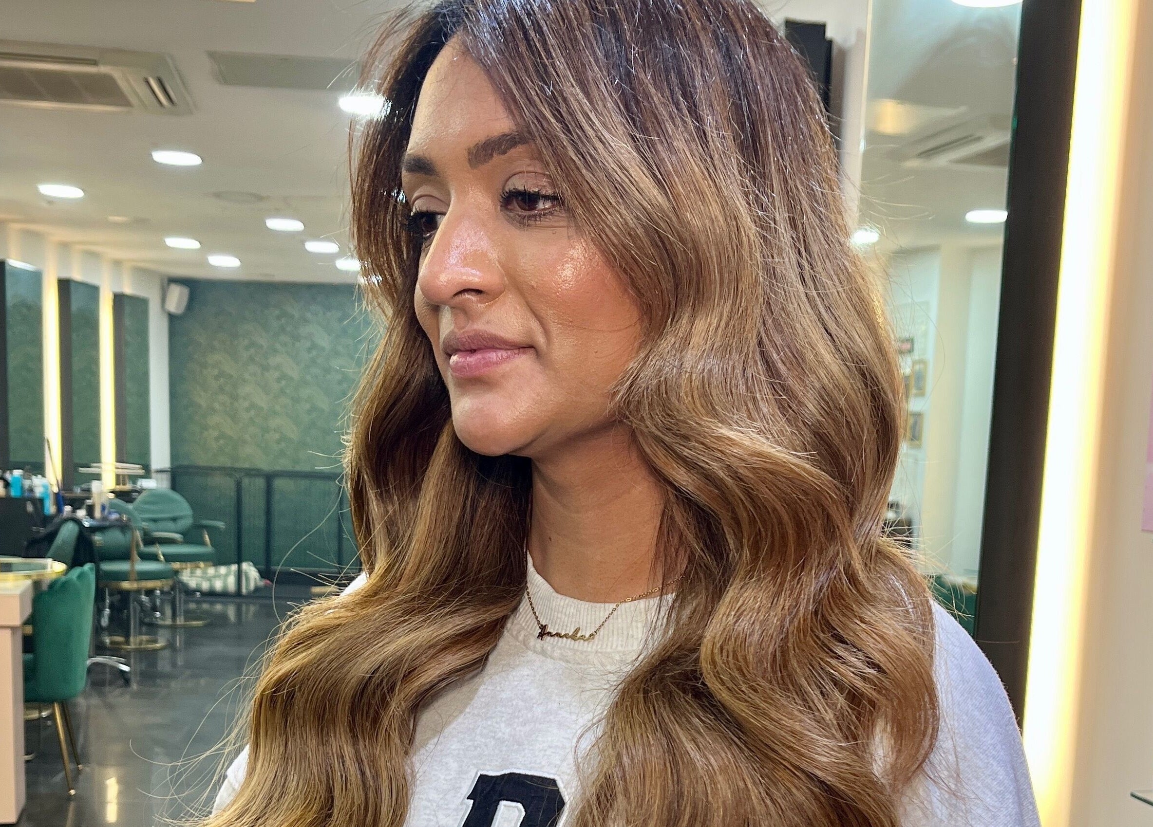 Warm-toned hair styled with waves at Aura Extensions, Twickenham, England, GB salon interior.
