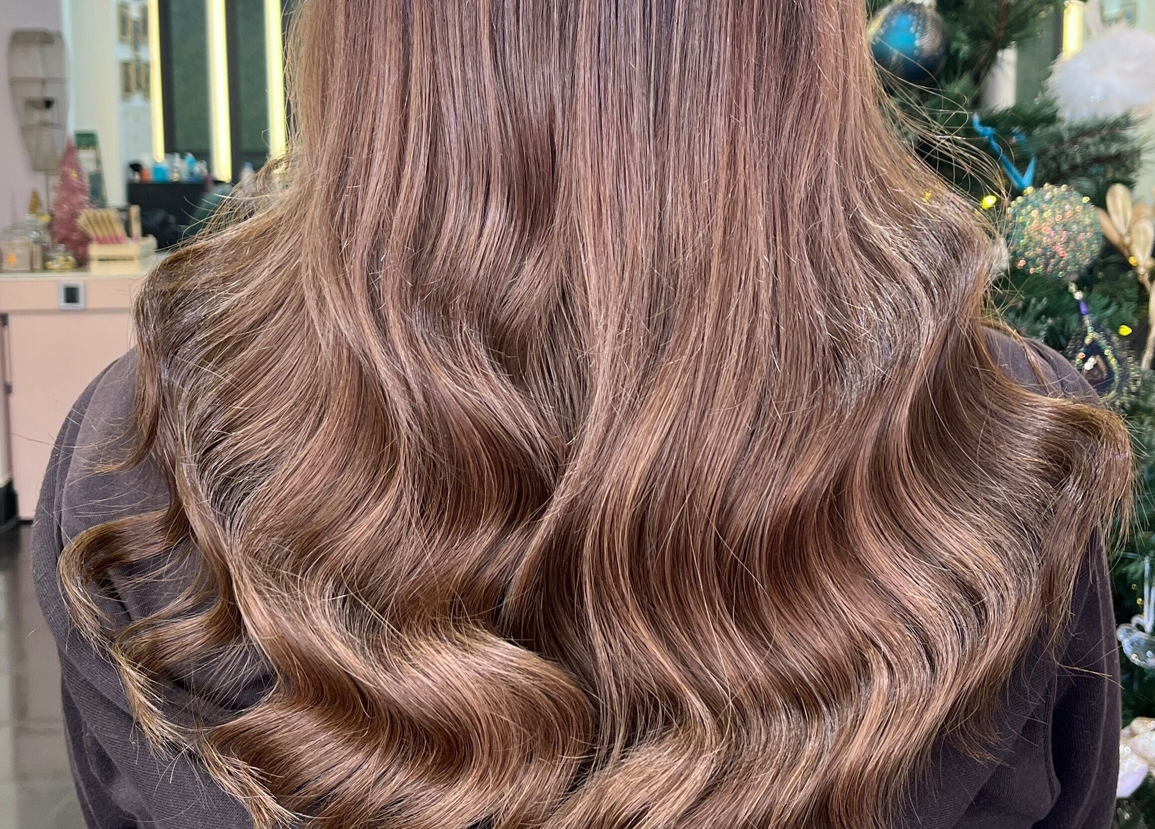 Close-up of wavy, silky hair at Aura Extensions, Twickenham, England, GB, styled for the holidays.