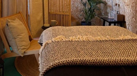 Relaxing therapy room at Massage Margate, Margate, GB with a rustic chair and a comfy massage bed.