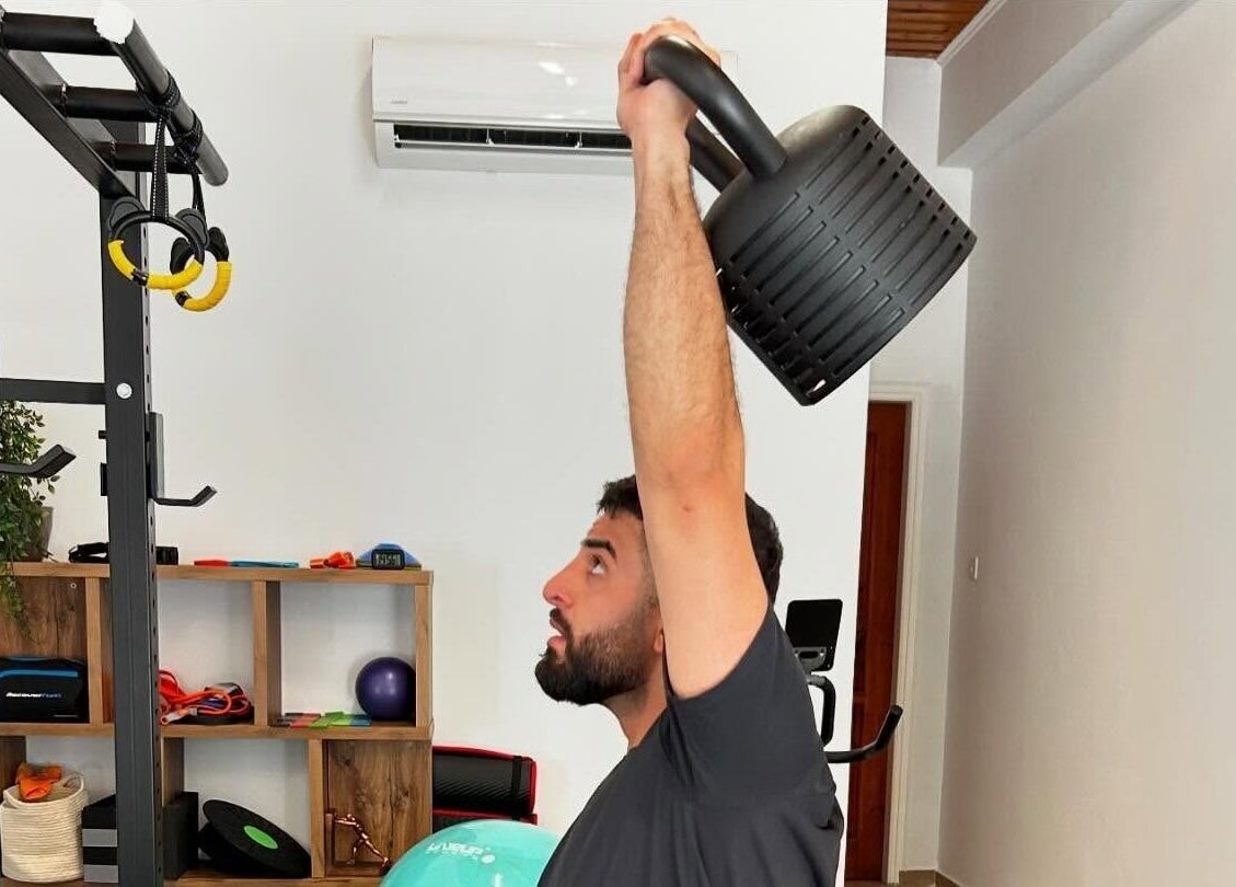 Client lifting kettlebell at Theramotion Physiotherapy, Λευκωσία, Λευκωσία, CY, enhancing strength.