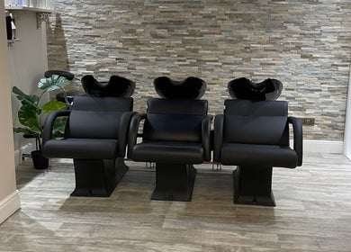 Stylish wash stations at Cabello Lounge in Southampton, England, GB with sleek chairs and stone wall backdrop.