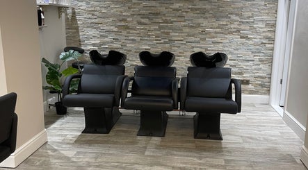 Stylish wash stations at Cabello Lounge in Southampton, England, GB with sleek chairs and stone wall backdrop.