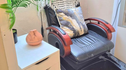 Luxury leather chair at The Beauty Retreat, Eastbourne, England with cushion and diffuser for serene ambiance.