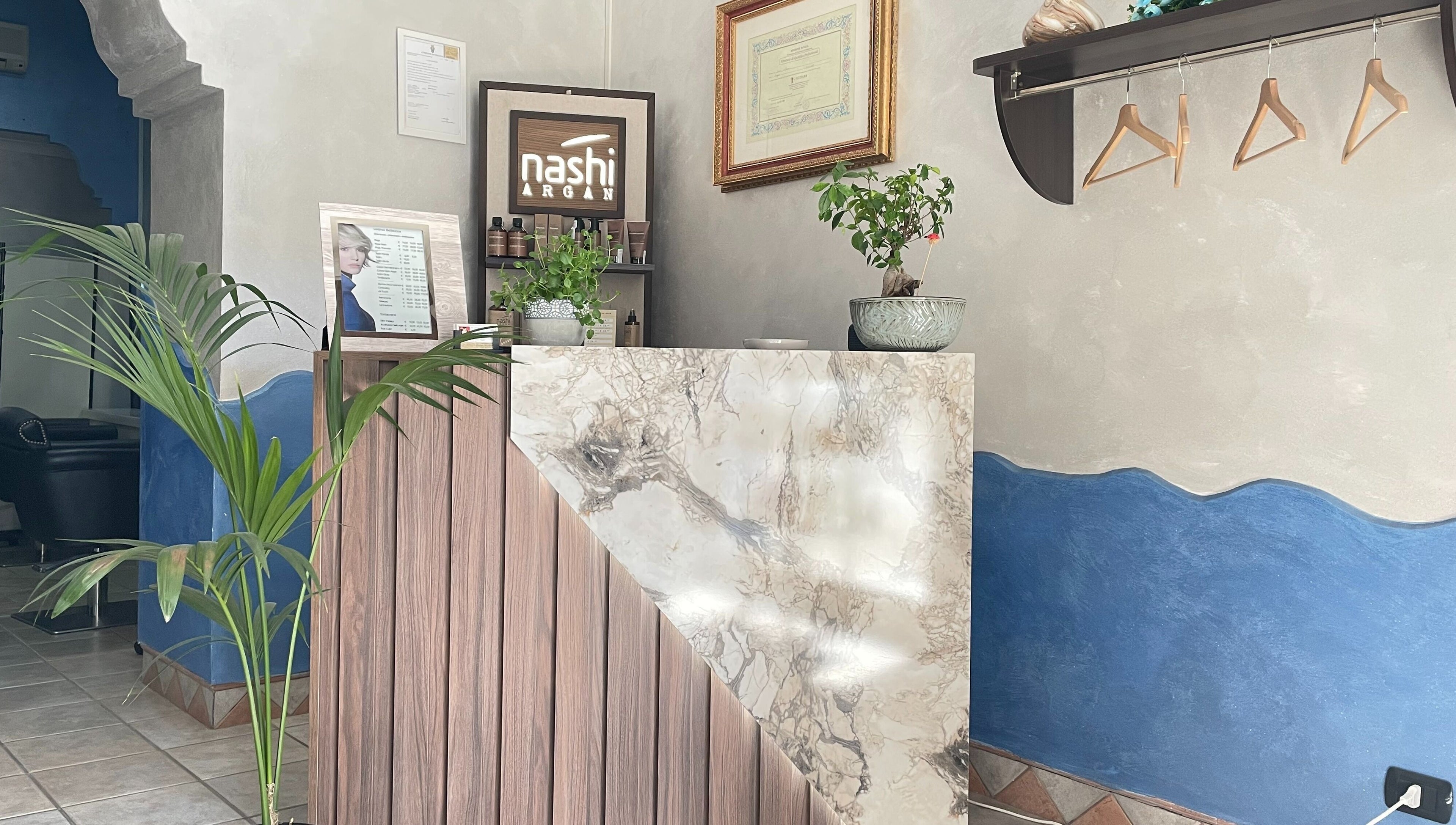 Entrata elegante di MC Carrisi Parrucchieri a Foggia, Puglia, IT con bancone in marmo e piante.