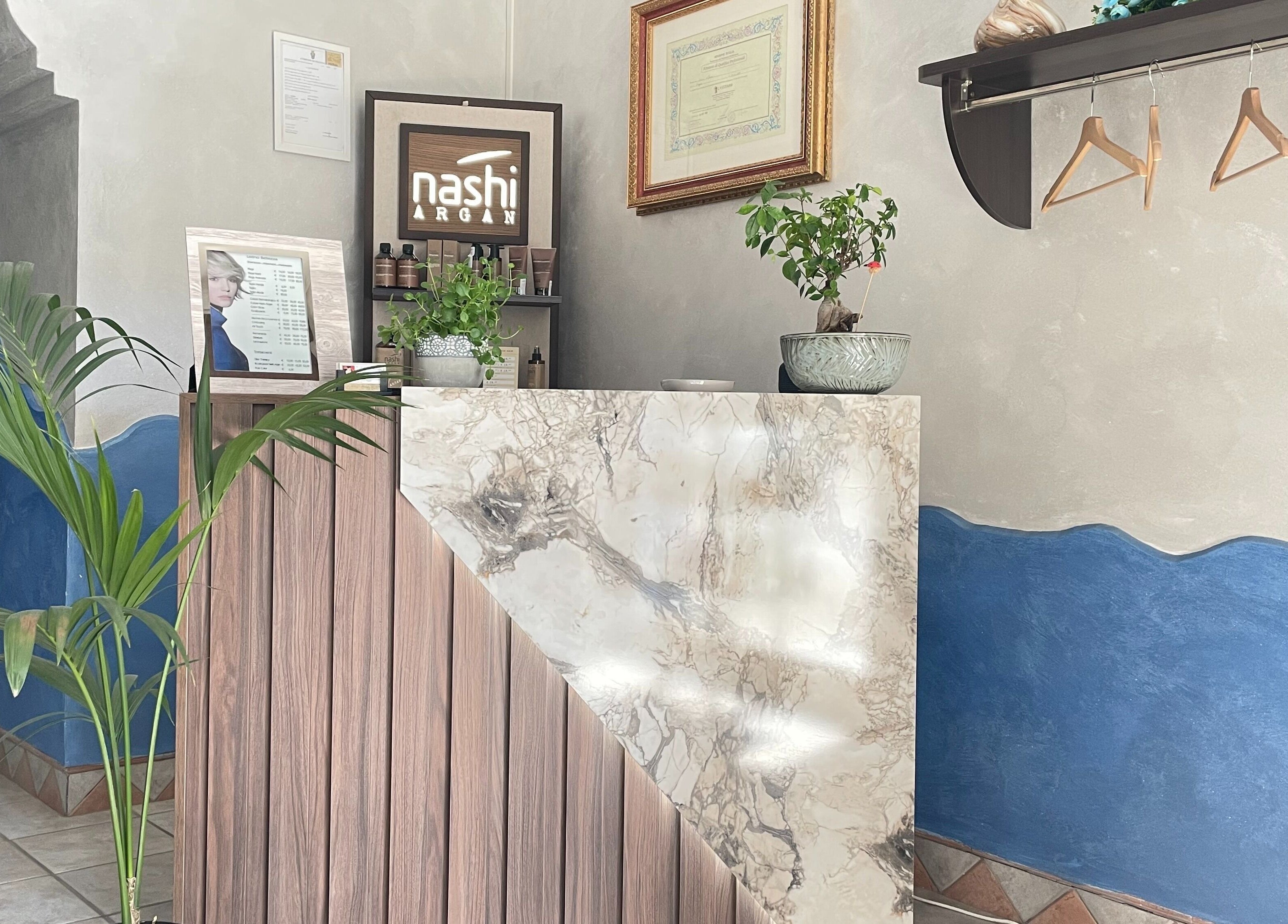 Entrata elegante di MC Carrisi Parrucchieri a Foggia, Puglia, IT con bancone in marmo e piante.