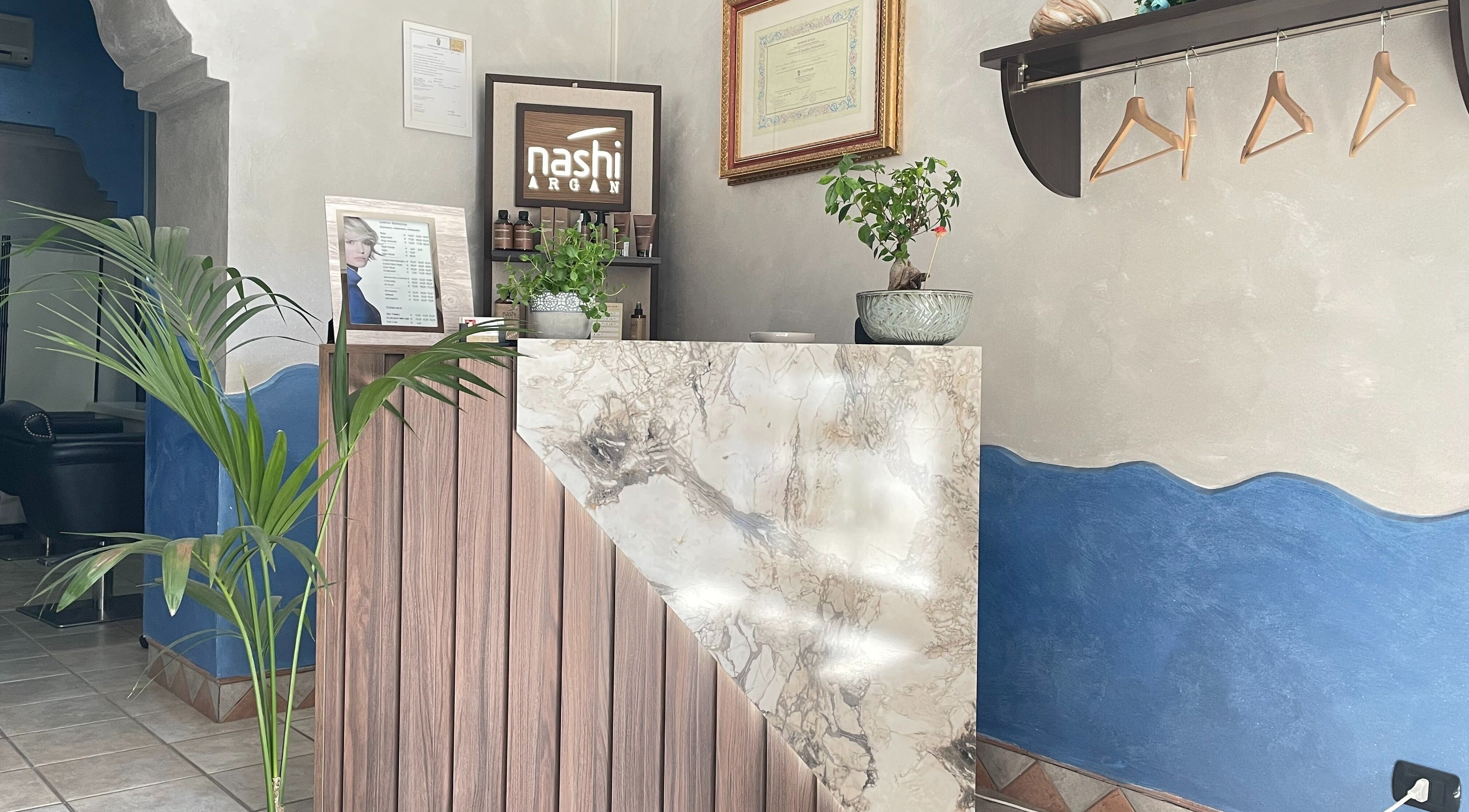 Entrata elegante di MC Carrisi Parrucchieri a Foggia, Puglia, IT con bancone in marmo e piante.