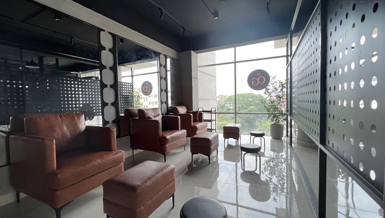 Modern lounge area at The Original Groomers, Dhaka, Dhaka Division, BD with leather chairs and large windows.