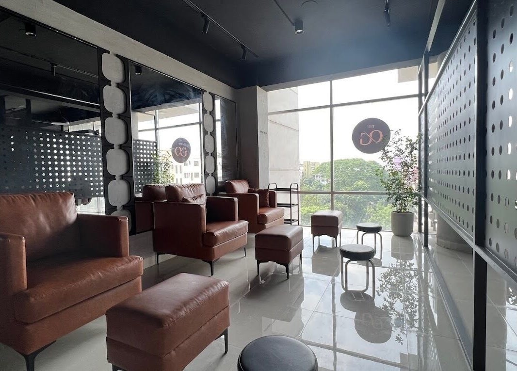 Modern lounge area at The Original Groomers, Dhaka, Dhaka Division, BD with leather chairs and large windows.