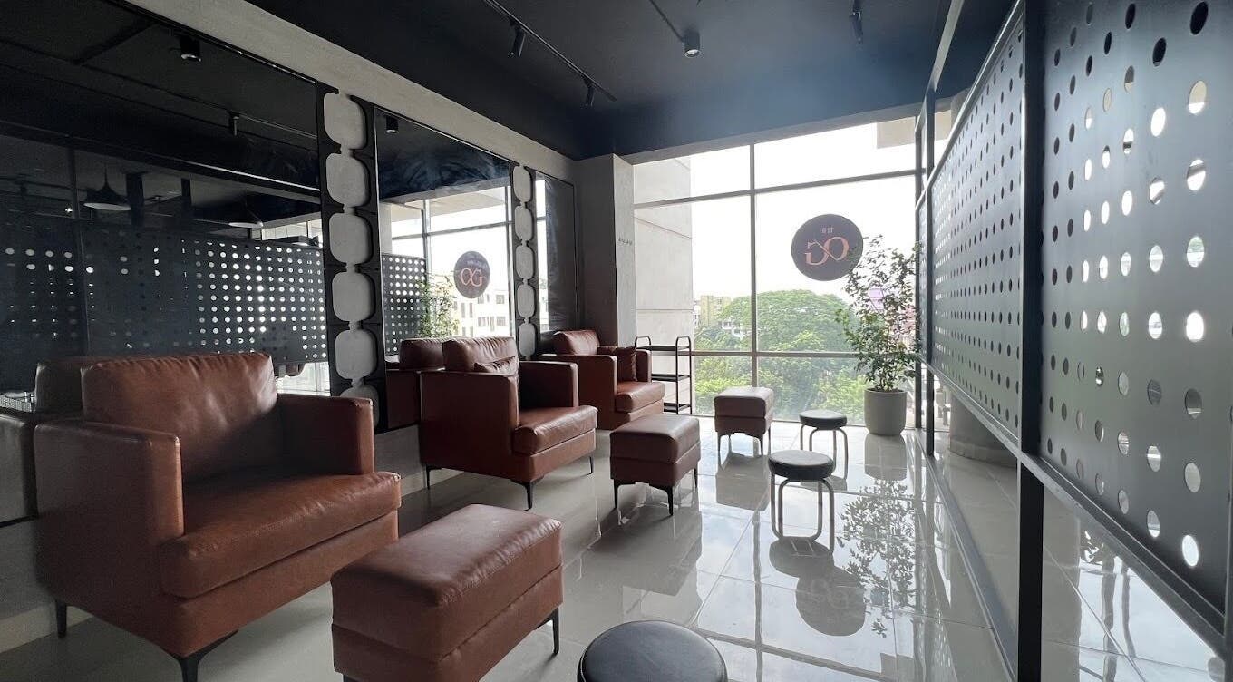 Modern lounge area at The Original Groomers, Dhaka, Dhaka Division, BD with leather chairs and large windows.