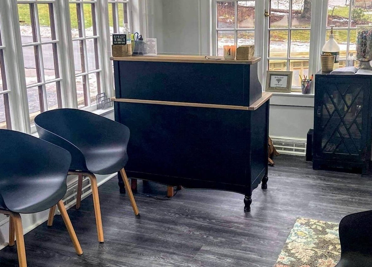 Elegant reception area at Mirage Salon, Jamestown, New York, US with modern seating and large windows.