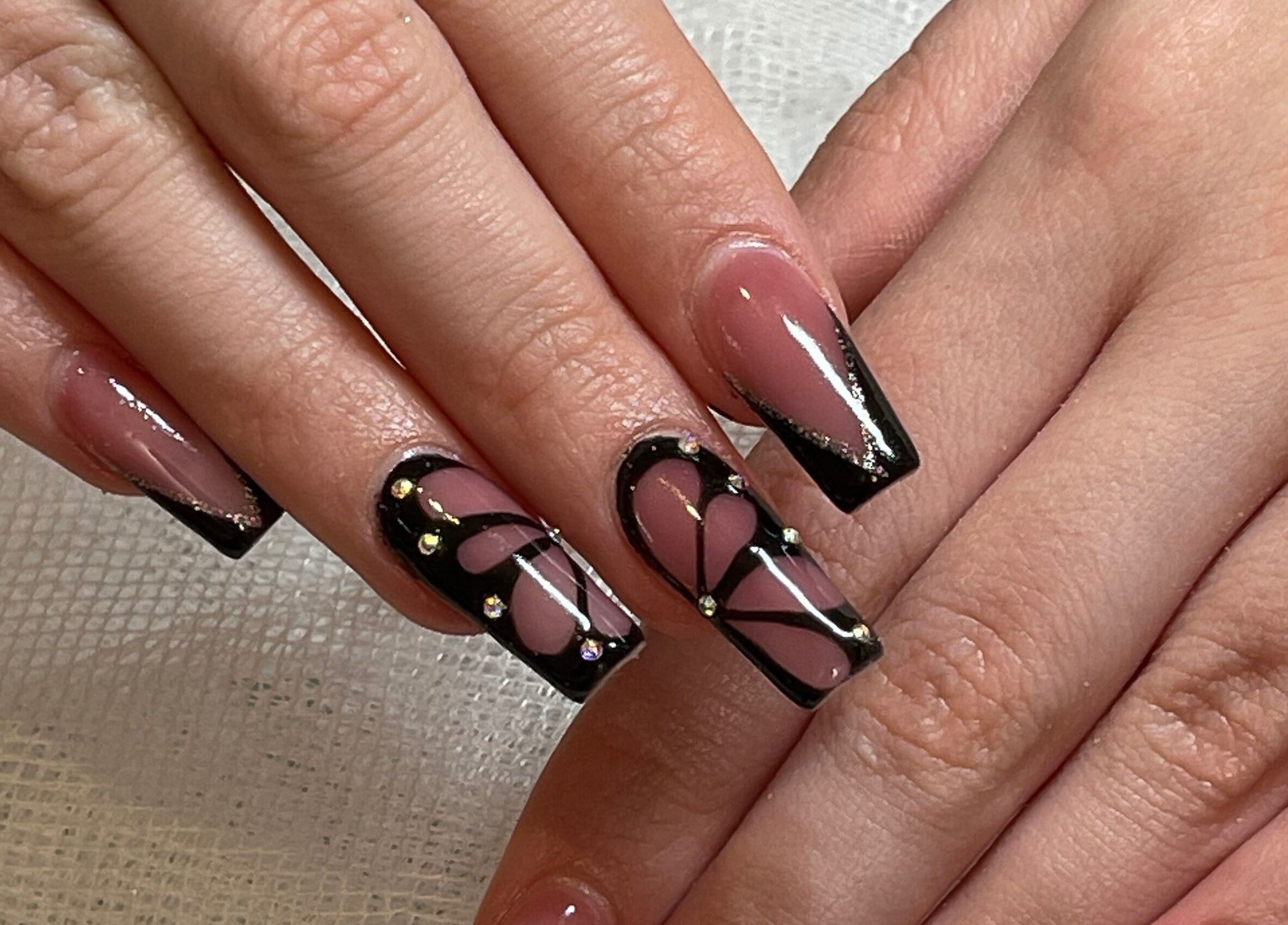 Intricate nail art design at Studio by Jess in Vancouver, British Columbia, CA showcasing black and pink patterns.