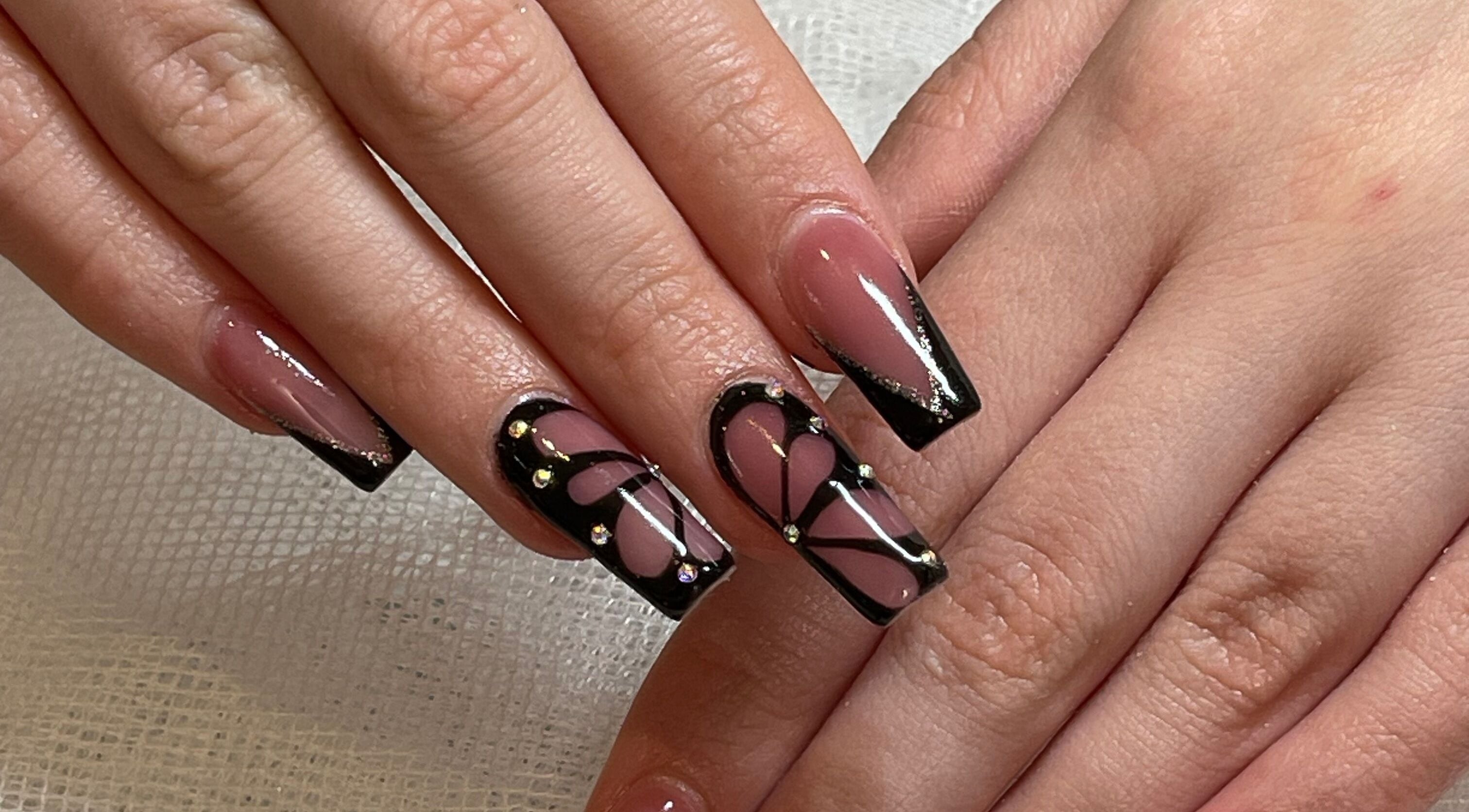 Intricate nail art design at Studio by Jess in Vancouver, British Columbia, CA showcasing black and pink patterns.