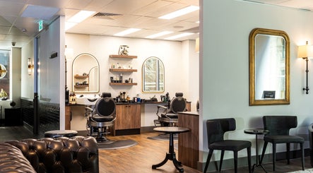 Chic interior of True Cut Barber Studio in Sydney, New South Wales, AU with plush seating and modern barber chairs.