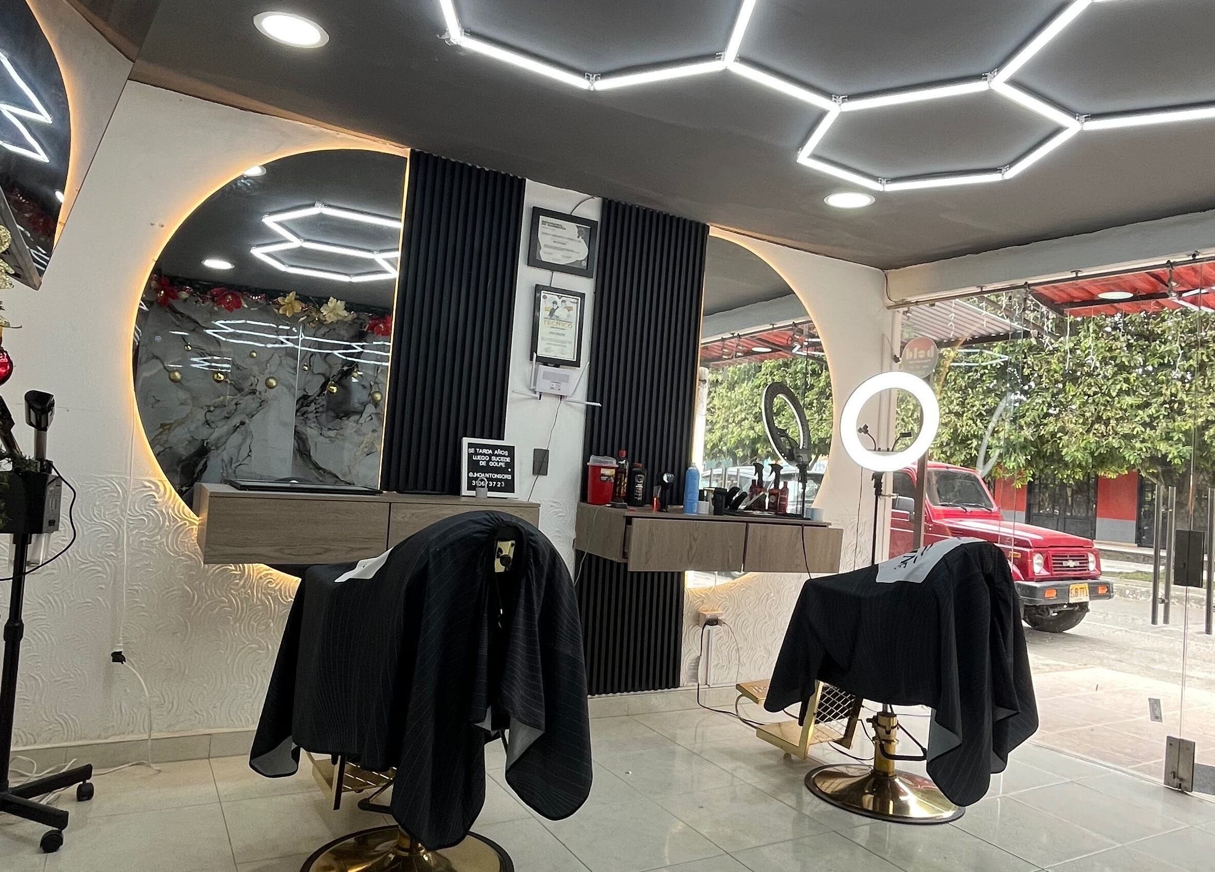 Interior moderno de JR STUDIO BARBER en Granada, Meta, CO con sillas y decoración elegante.