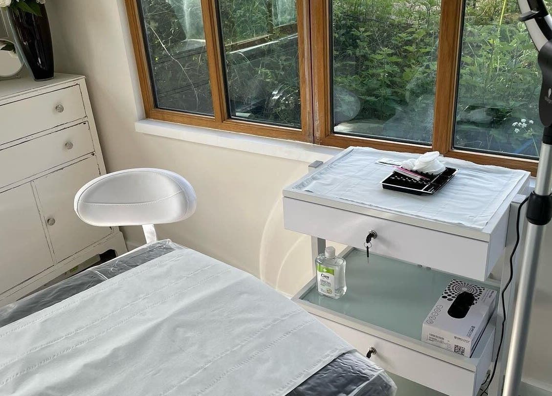 Bright treatment room at Rachael Loco Permanent Makeup in Dorchester, England, GB with white furnishings.