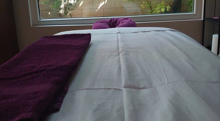Κρεβάτι μασάζ με μωβ πετσέτα στο Euphoria Aura, Limassol, CY.