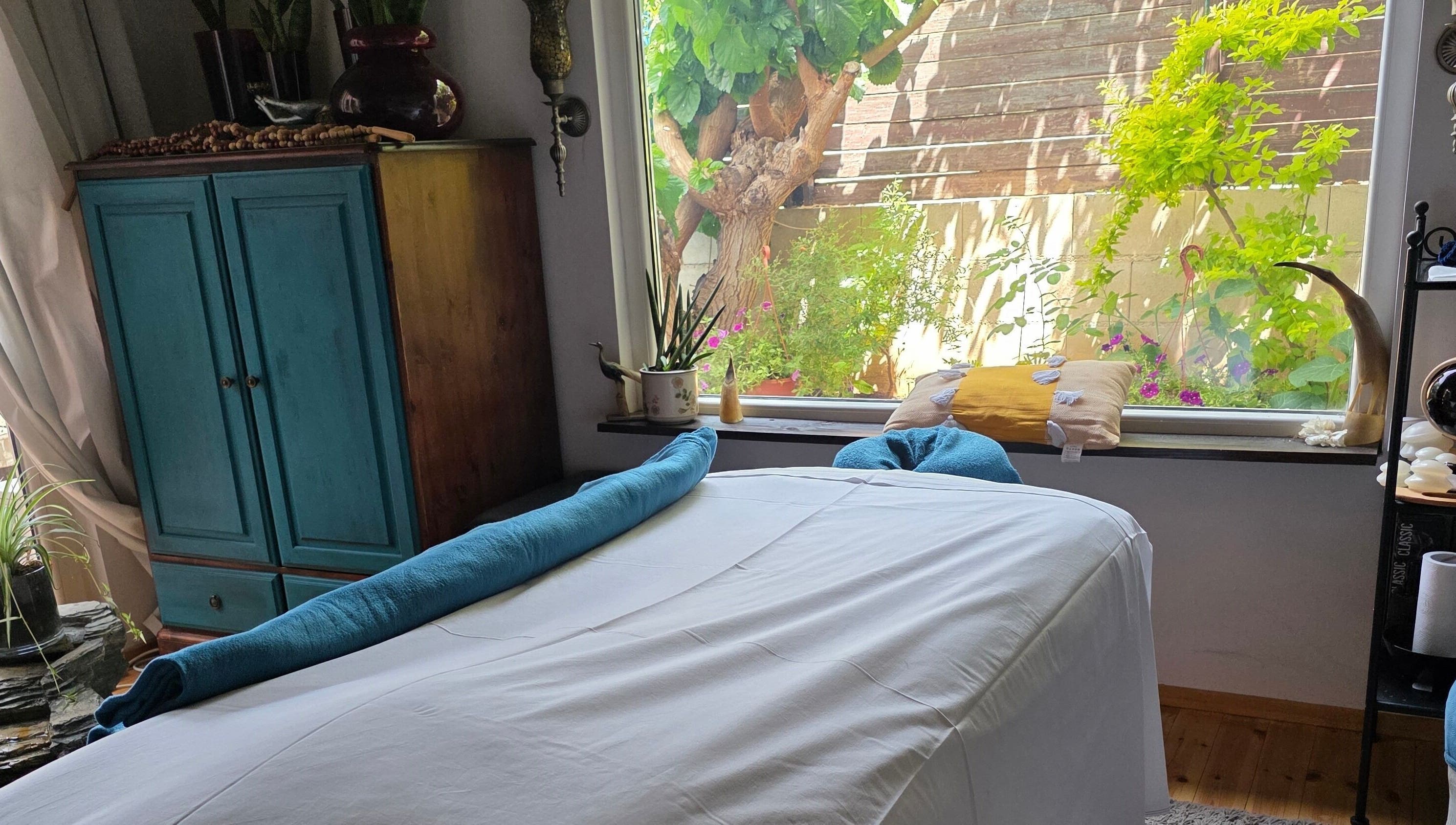 Χαλαρωτικός χώρος μασάζ στο Euphoria Aura, Λεμεσός, CY, με θέα στον κήπο.