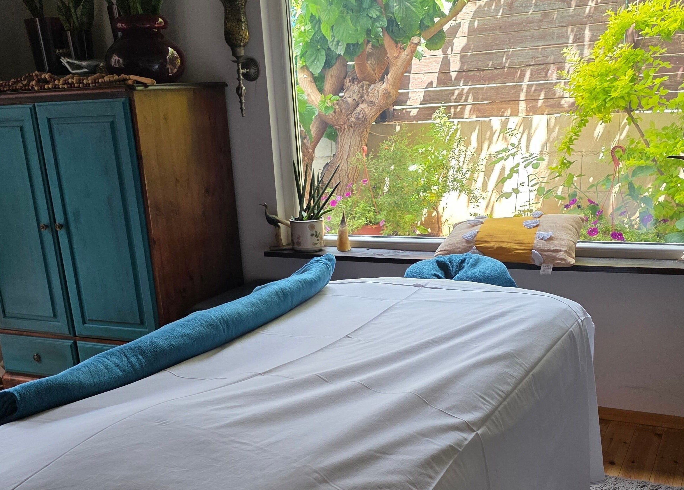 Χαλαρωτικός χώρος μασάζ στο Euphoria Aura, Λεμεσός, CY, με θέα στον κήπο.