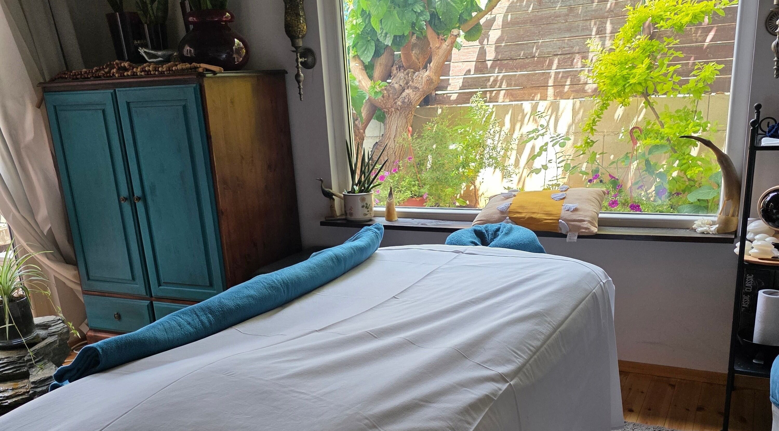 Χαλαρωτικός χώρος μασάζ στο Euphoria Aura, Λεμεσός, CY, με θέα στον κήπο.