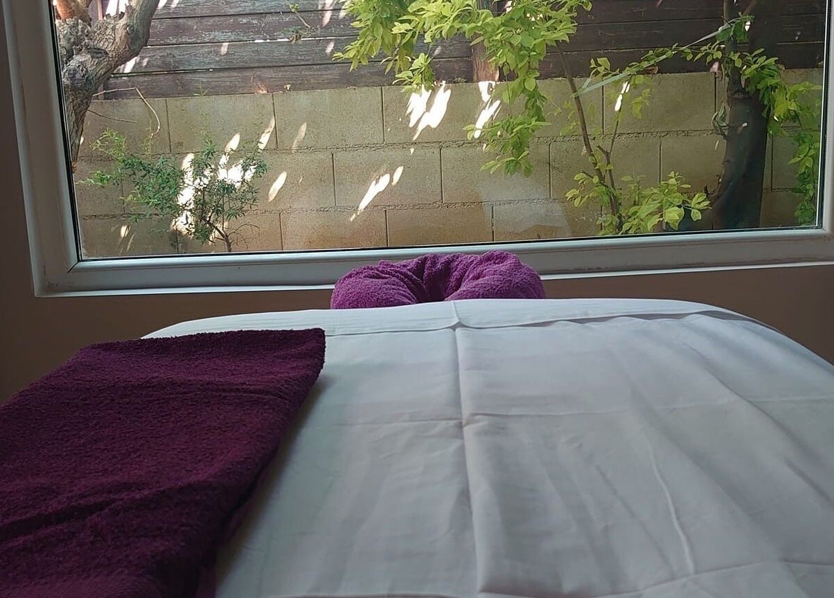 Δωμάτιο μασάζ στο Euphoria Aura, Λεμεσός, CY, με θέα σε πράσινο τοπίο από το παράθυρο.