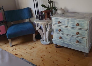 Κομψό εσωτερικό δωματίου στο Euphoria Aura, Limassol, CY με γαλάζια καρέκλα και vintage ράφια.