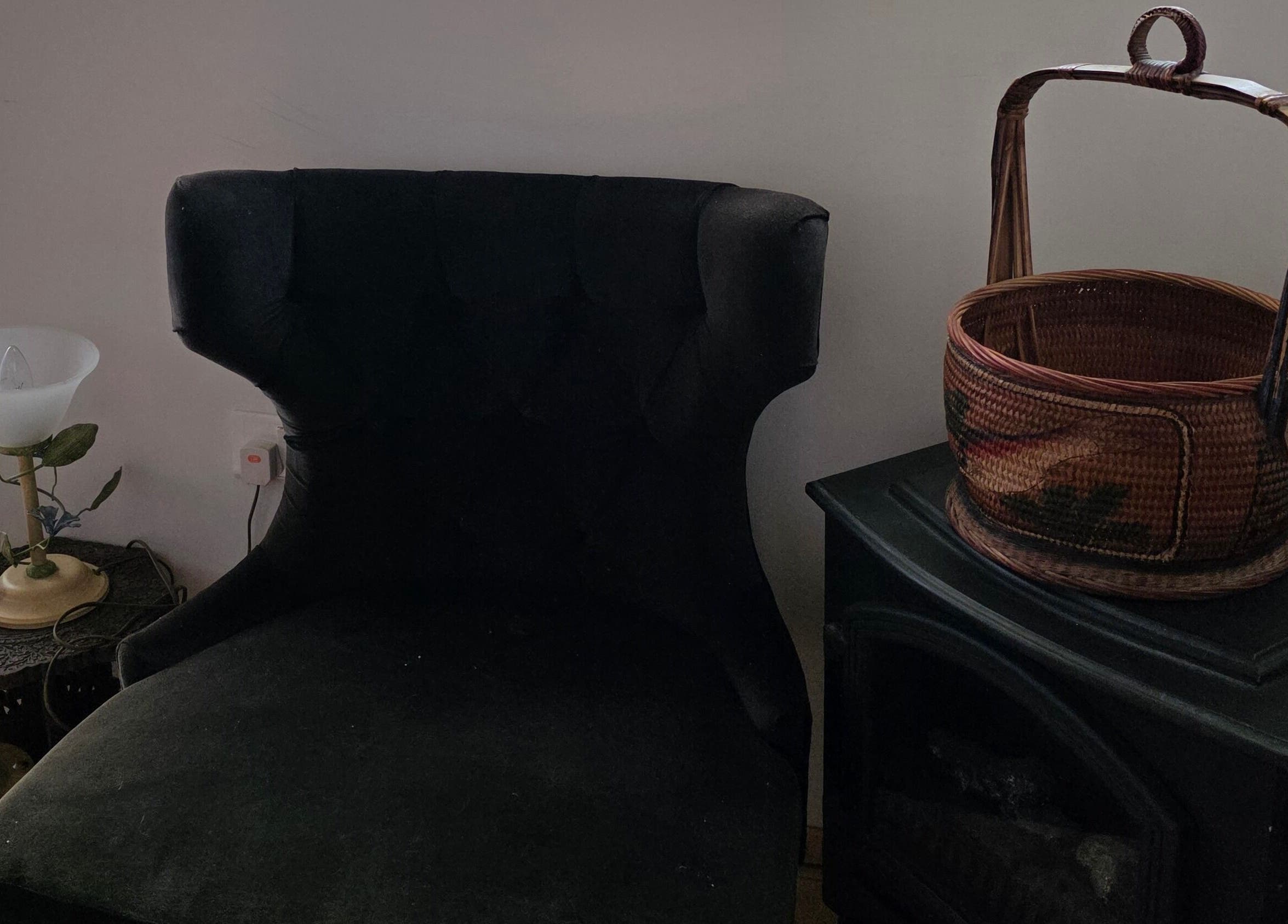 Κομψή γωνία καθιστικού στο Euphoria Aura, Λεμεσός, CY με μαύρη πολυθρόνα και διακοσμητικό καλάθι.