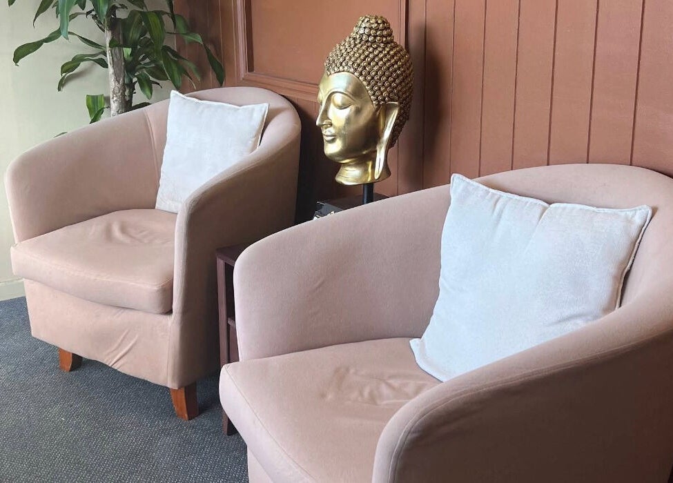 Plush seating with Buddha head statue at Ploythai Massage and Spa, Wynnum, Queensland, AU.